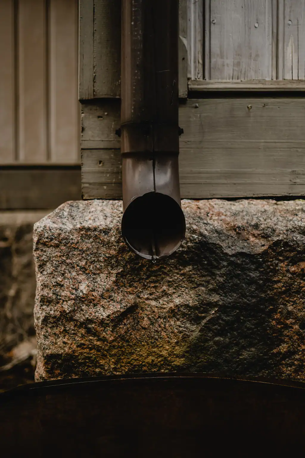 Drainpipe and downspout on a stone wall, contact The Drain Masters in Swindon